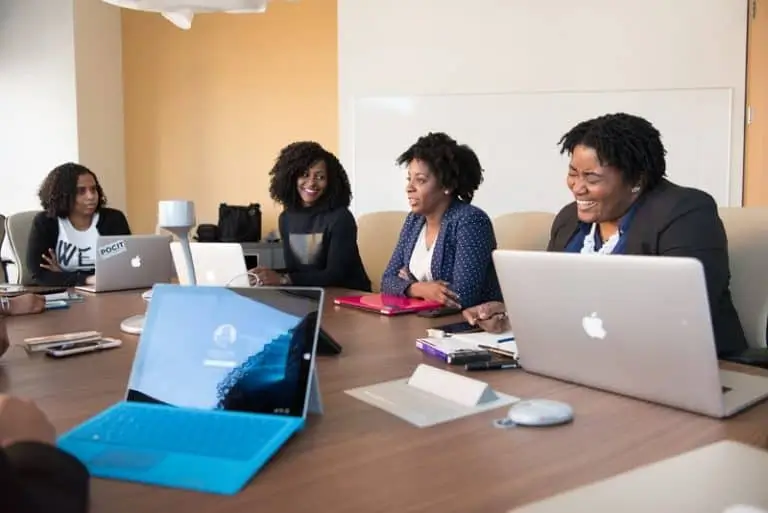 Women in a meeting around a table with computers_AutoRABIT